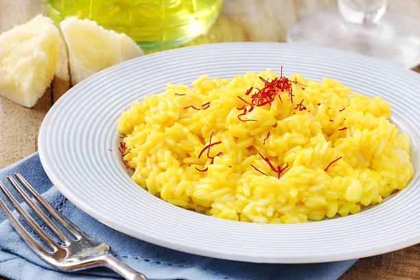 Italian saffron risotto Italian saffron risotto - Risotto alla milanese - decorated with red saffron threads flower stigma photos stock pictures, royalty-free photos & images