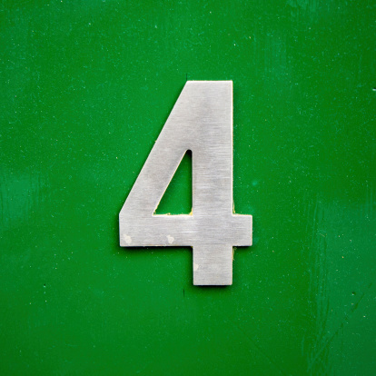 metal house number four on a green lacquered panel