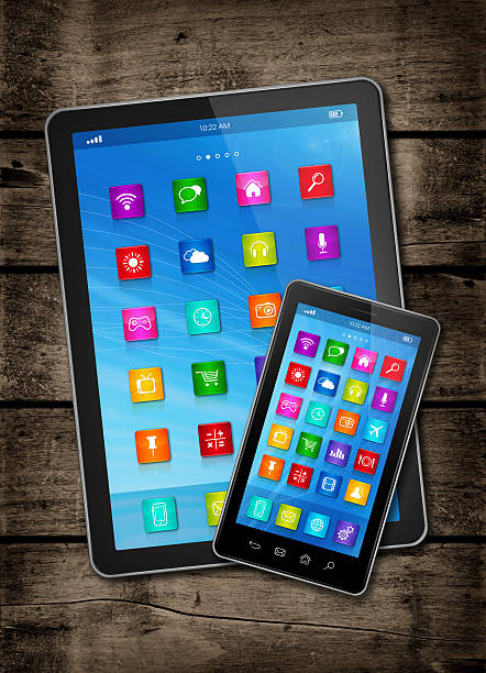 istock Smartphone and digital tablet PC with icons on wood table 487306462