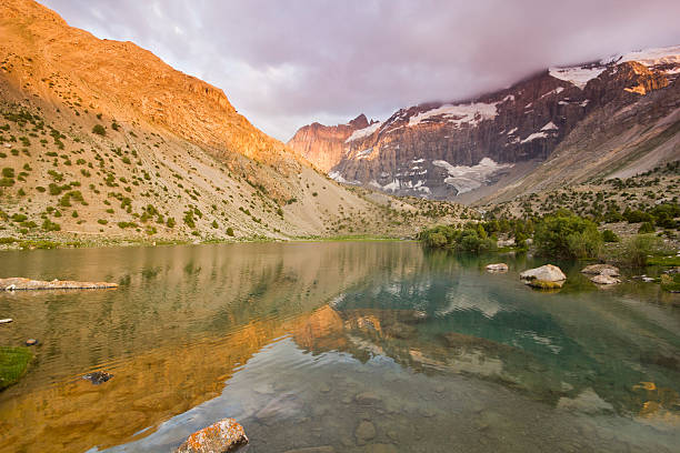 istock blue mountain lake surrounded by high peaks at sunset 487306538