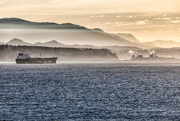 Freighter and industry in San Juan Islands, near Seattle. Late afternoon, setting sun in background. Natural fog blended with haze generated by WA state forest fires.