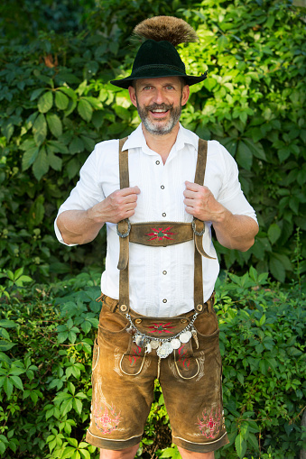 portrait of a bavarian man with hat and leather pants