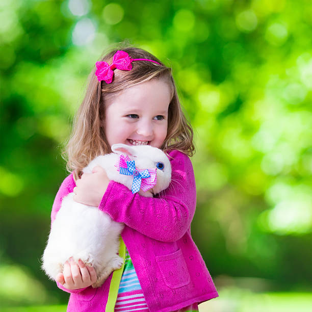 istock Little girl playing with rabbit 487309872
