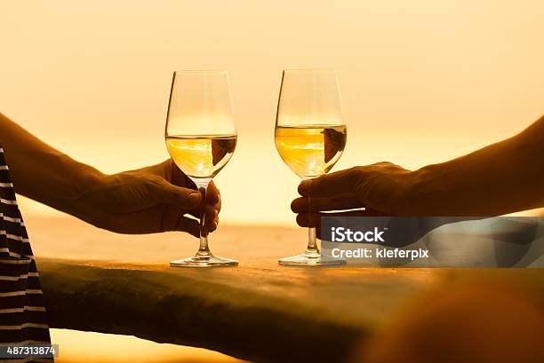 Couple Enjoying Wine By The Sea Stock Photo - Download Image Now - Date Night - Romance, Softness, Dinner