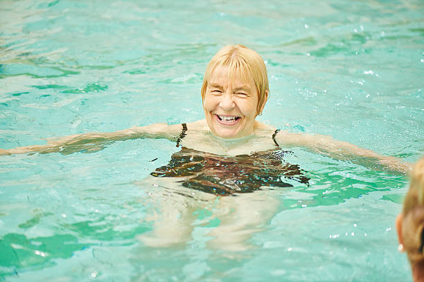 istock senior ladies having fun in swimming pool 487314466