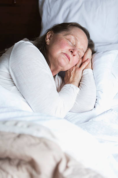 istock Senior woman asleep in bed 487317158