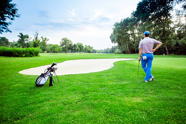 istock Beautiful golfing scenery with a golfer holding a club 487323682