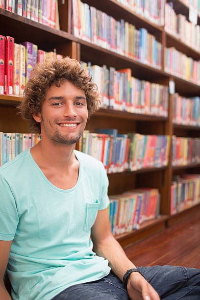 istock Male college student smiling in library 487327491