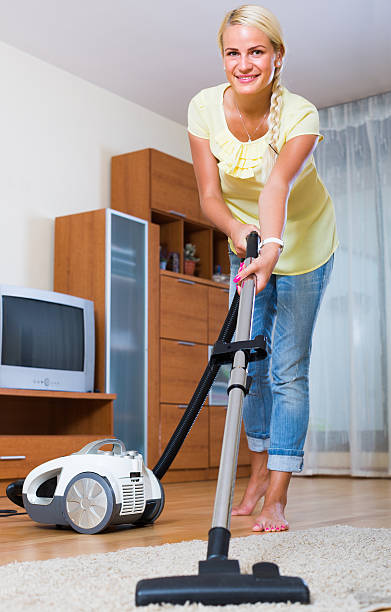 istock Housewife vacuuming at home 487328810