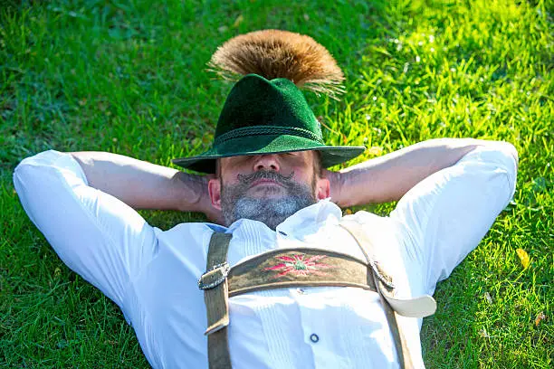 Photo of bavarian man sleeping on the grass