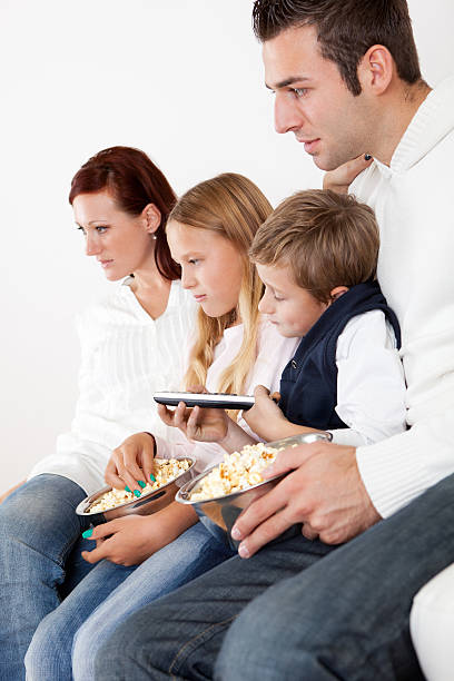 istock Cheeful young family watching TV at home 487330527