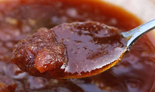 Close up of date molasses with silver spoon