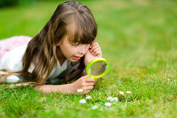 istock Young girl with microscope in garden 487334162