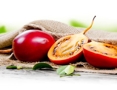 Photo of tamarillo fruit with leaves on burlap with white space