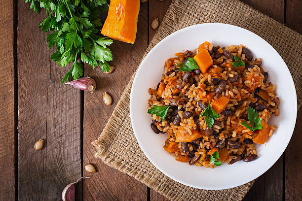 Mexican vegan vegetable pilaf with haricot beans and pumpkin Mexican vegan vegetable pilaf with haricot beans and pumpkin beans and rice stock pictures, royalty-free photos & images