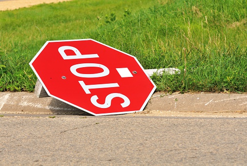 Stop sign fallen by the curb.