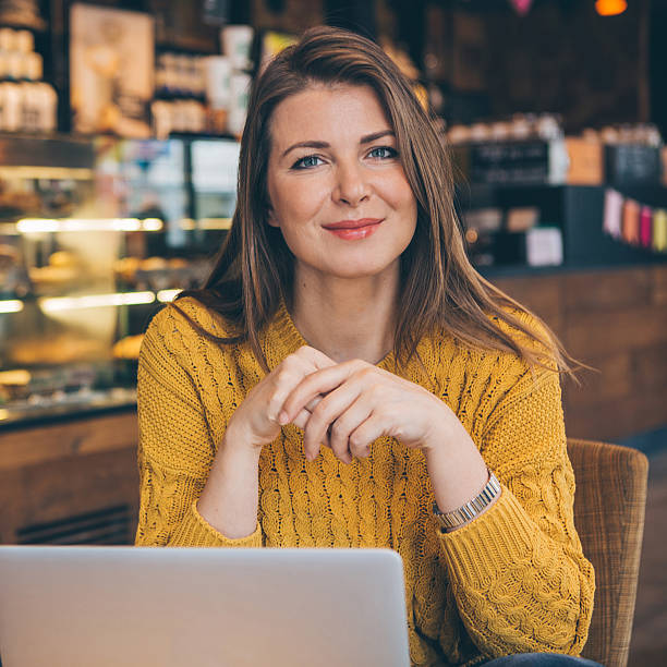 Woman with laptop at cafe.
