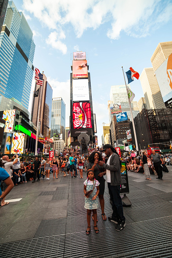 New York City, NY, USA - August 27, 2015: Little girl with family take in the sights in Times Square. Tourists all around. 