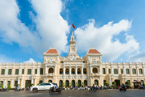 Ho Chi Minh City, Vietnam - Jun 10, 2015: The Saigon City Hall viewed from the new Pedestrian Park on Jun 10, 2015. The City Hall built in 1902 - 1908 in French Colonial style and located on the end of old and famous Nguyen Hue Boulevard, which were transform to the Pedestrian Park from May 2015. The standing statue of Ho Chi Minh are replaced the old sitting one with 7.2 m tall.