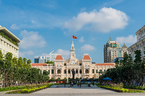 Ho Chi Minh City, Vietnam - Jun 10, 2015: The Saigon City Hall viewed from the new Pedestrian Park on Jun 10, 2015. The City Hall built in 1902 - 1908 in French Colonial style and located on the end of old and famous Nguyen Hue Boulevard, which were transform to the Pedestrian Park from May 2015. The standing statue of Ho Chi Minh are replaced the old sitting one with 7.2 m tall.