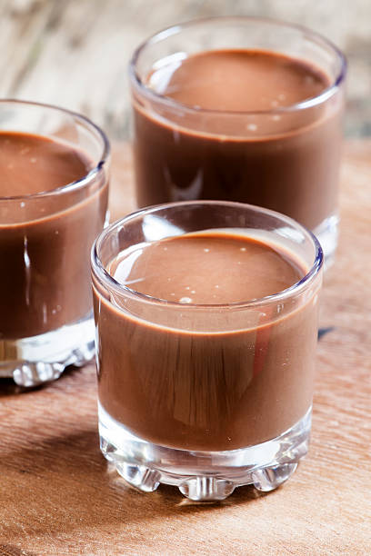 istock Liquid chocolate in a glass on the old wooden background 487355000