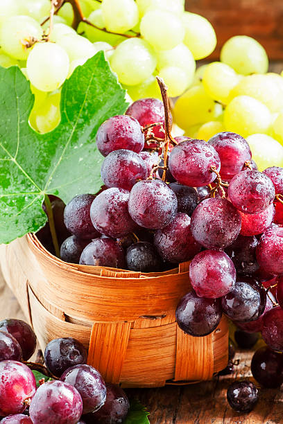 istock Purple round ripe grapes in a wicker basket 487355330