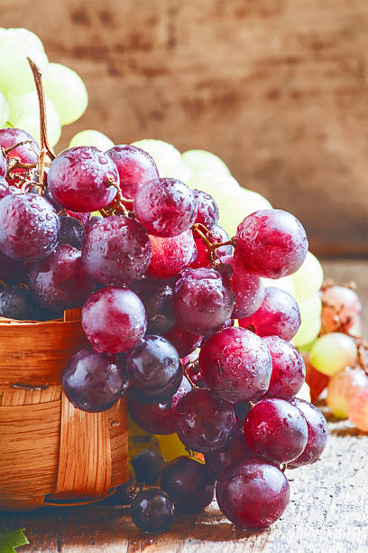istock Purple round ripe grapes in a wicker basket 487355342