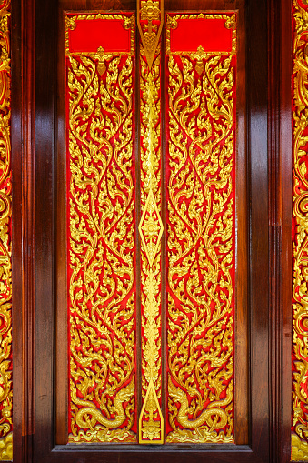 Buddhist church door with Thai art sculpture. Generally in Thailand, any kind of art decorated in Buddhist church, temple pavilion, temple hall, monk's house etc. created by money donated people to hire artist. They are public domain or treasure of Buddhism, no restriction in copy or use, no name of artist appeared (but if it's appeared, it's only for telling who the artist is.