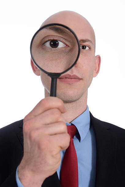 istock Businessman with magnifying glass on eye 487359353