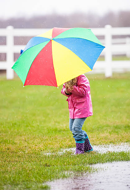 istock Young Girl in Rain With Umbrella 487361599