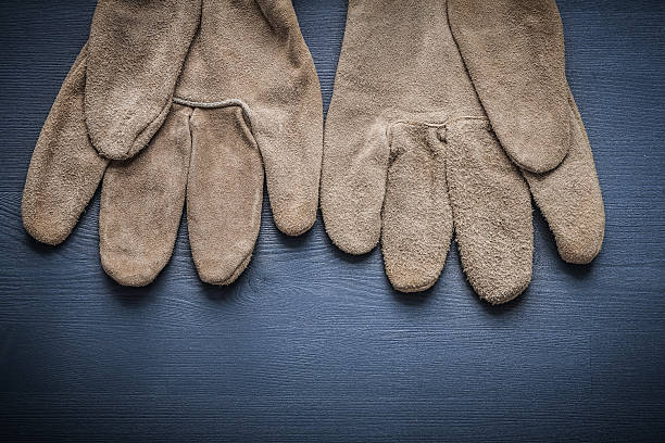 istock pair of protective working gloves on wooden board 487362150