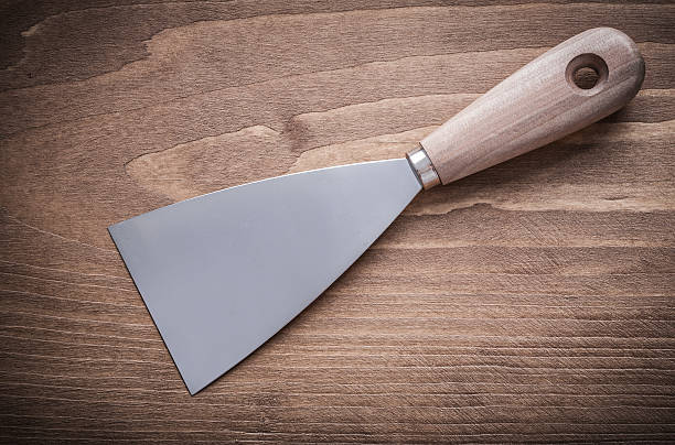 istock steel putty knife on wood board 487362462