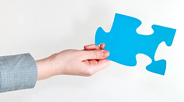 istock blue puzzle piece in female hand 487362601
