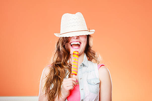 Funny little girl eating exotic fruit in summer in the garden on a blurred background.