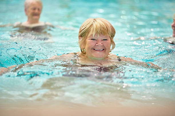 istock senior ladies having fun in pool 487371952