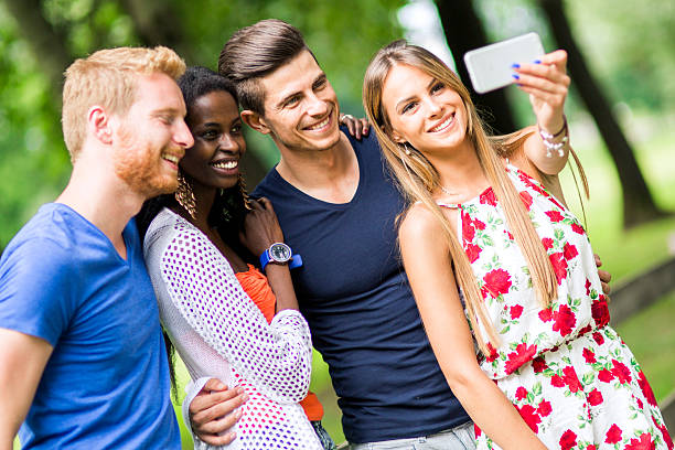 istock Group of young people and couples taking selfies in nature 487380374