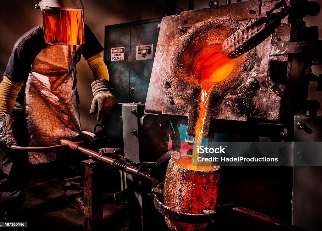 Liquid Molten Steel Industry Worker pouring liquid metal into crucible. Metal Ore Stock Photo
