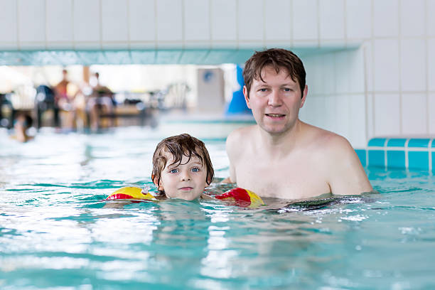 istock Young dad teaching his little son to swim indoors 487380534