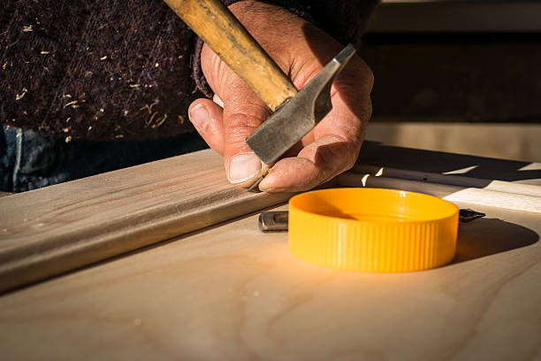 istock Man hammering nail into wood with sunlight. 487384004
