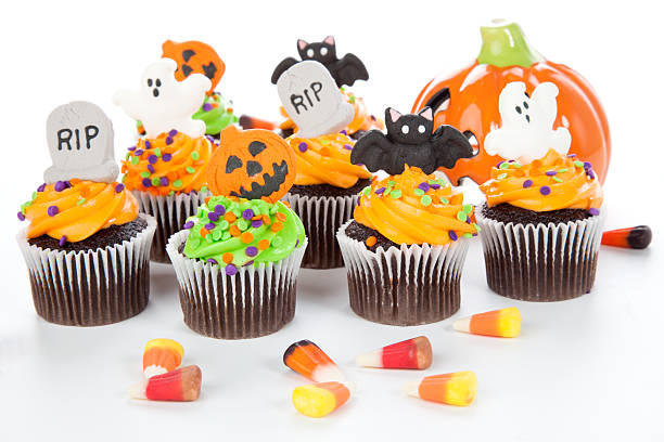 Halloween cupcakes Halloween cupcake with RIP, ghost, bat, and  jack-o'-lan·tern decorations surrounded by Halloween cupcakes, corn candies, and decoration. halloween cupcake stock pictures, royalty-free photos & images