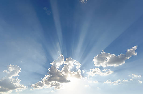 istock Bright sun rays shooting out of small clouds (wide version) 487387712