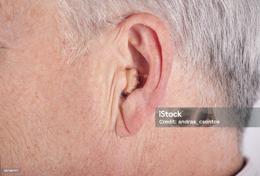 Senior wearing CIC hearing aid Close-up of a senior man's ear wearing a CIC (Completely In the Canal) hearin aid AIDS Stock Photo