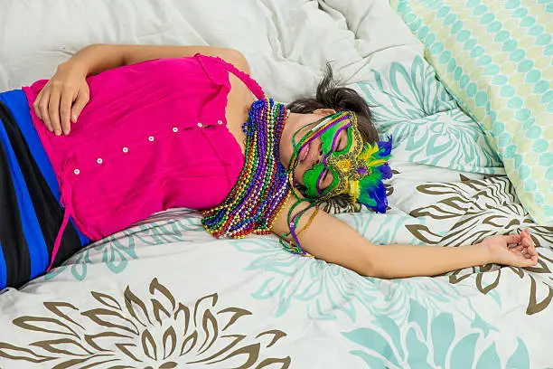 Woman passed out on bed during Mardi Gras