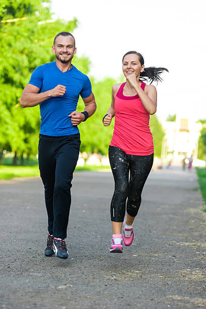 istock Runners training outdoors working out. City running couple jogging outside 487390316