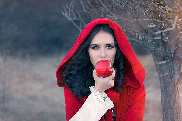 à capuche rouge femme tenant apple portrait de conte de fées - fairy forest women magic photos et images de collection