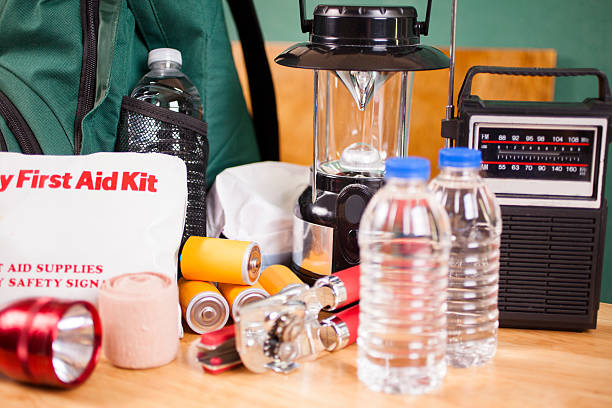 Emergency preparedness natural disaster supplies. Water, flashlight, lantern, batteries. Emergency preparedness supplies. A large pile of supplies to be used in case of a natural disaster (hurricane, flood, earthquake, etc.) including: flashlight, backpack, batteries, water bottles, first aid kit, lantern, radio, can opener, mask. No people. flood preparation stock pictures, royalty-free photos & images