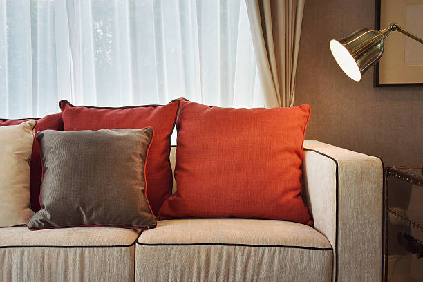 istock Red and deep brown linin pillows on beige sofa 487399656
