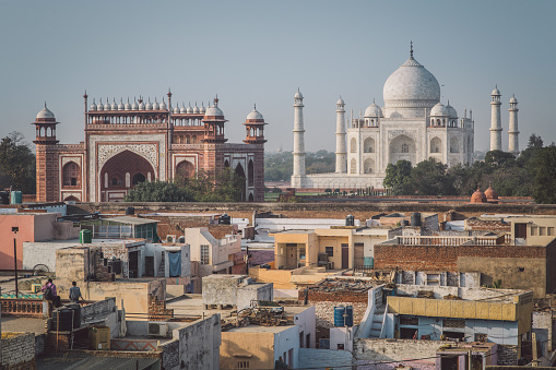 Agra, India - February 27, 2015: Taj Mahal, Great Gate and rooftops of neighbouring houses. Post-processed with grain, texture and colour effect.
