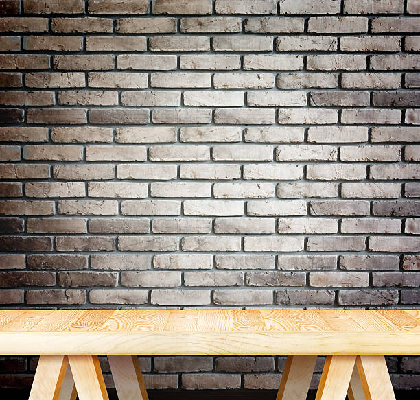 Empty wood modern table and grunge brown brick wall