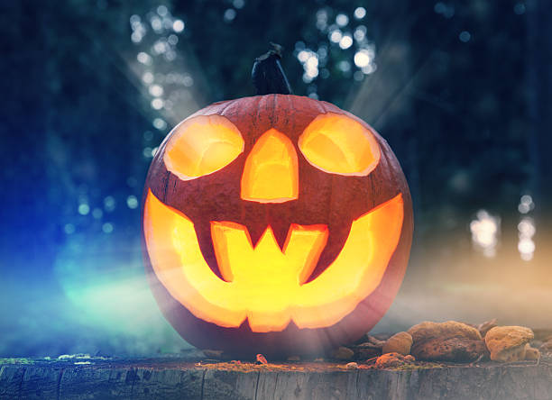istock Halloween pumpkin in a forest at night 487409030